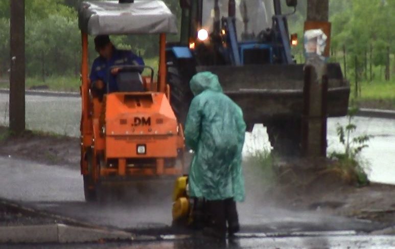 Асфальт кладут не только в лужи, но и во время проливного дождя. Видео